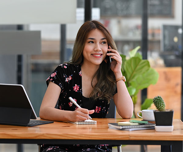 Account manager talking on the phone and taking note on notebook